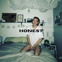 a man sitting on top of a bed with the word honest